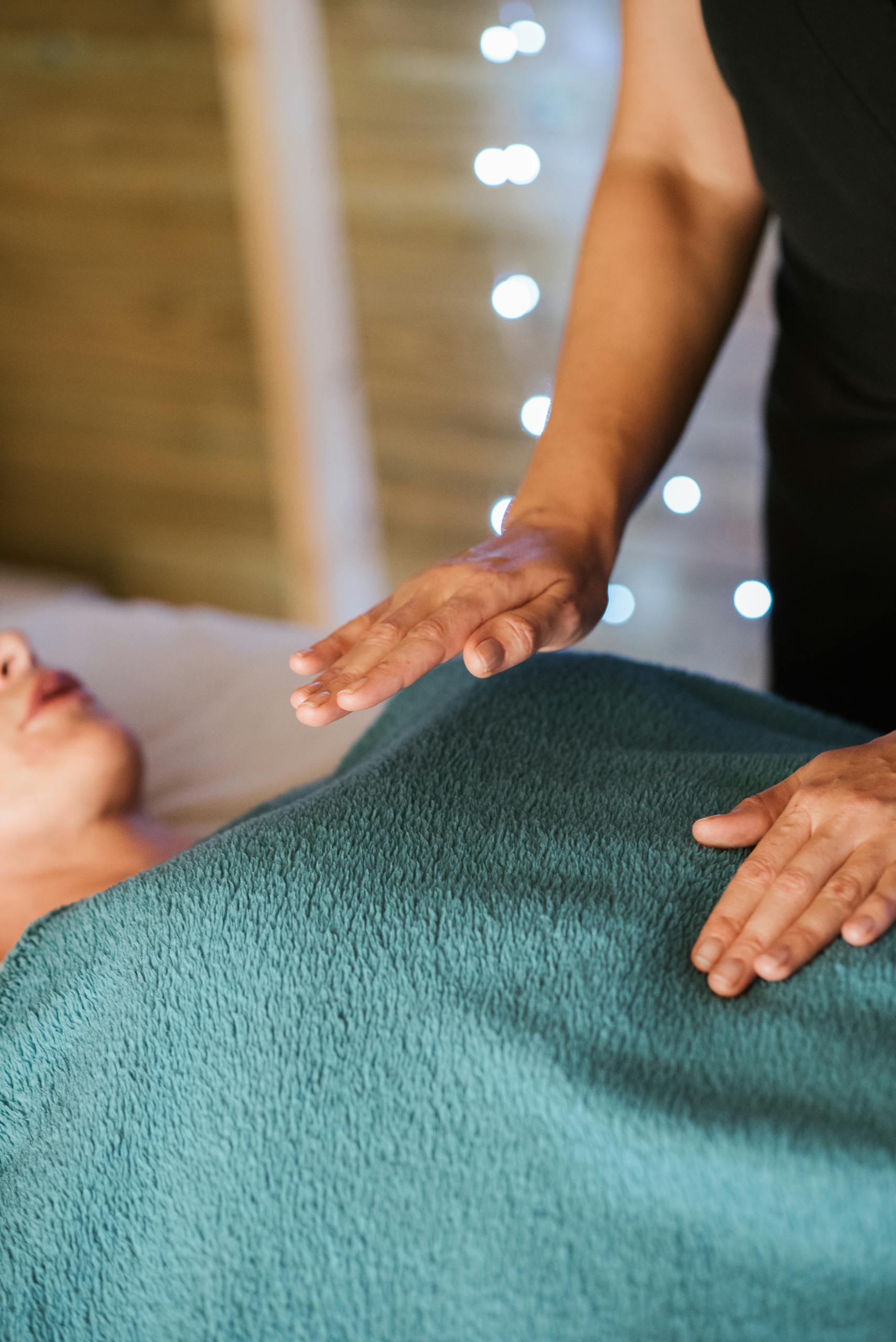Faceless adult female having massage in towel on comfortable couch in spa salon